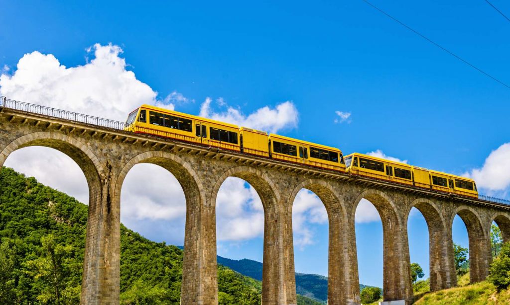 Gele trein op een viaduct in Frankrijk